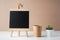 Blank blackboard with paper cup and green plant on white table.zero waste and eco friendly learning concept