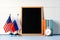 Blank blackboard with USA and Russia flags on wooden background