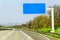 Blank blue freeway sign over the road on sunny day