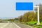 Blank blue freeway sign over the road on sunny day