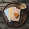 Blank books with heart shaped cake on a wooden tray