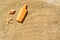 Blank bottle of sunscreen, starfish and seashell on sand, flat lay. Space for text