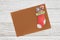 Blank brown holiday season greeting card with pen on a weathered whitewash wood background