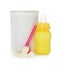 Blank can of powdered infant formula with feeding bottle and scoop on white background. Baby milk