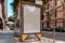 Blank canvas white outdoor banner at bus stop next to facade of ancient building at european town.