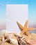 Blank card on sand beach and sea shells