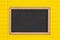 Blank chalkboard on bright yellow ruled line notebook paper background