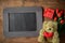 Blank chalkboard with teddy bear and flowers