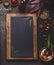 Blank chalkboard in wooden frame and cooking ingredients on dark kitchen table background