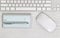 Blank checkbook on white desktop with pen and mouse