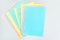Blank checkered pages from a folding notebook in different pastel colors scattered on silver desk