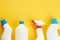 blank chemicals bottles on a bright yellow background. copy space. cleaning and washing concept