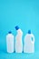 blank chemicals bottles over blue background. vertical orientation. cleaning service concept