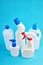 blank chemicals bottles over blue background. vertical orientation. cleaning service concept