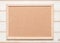 Blank cork board with corkboard texture background with wooden frame hanging on white wood wall for bullentin, memo or noticeboard