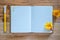 Blank diary notebook, yellow flower and pen on wooden table