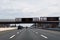 Blank electronic information sign over a busy multi-lane highway that says to move over and slow down for emergency vehicles.