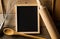 Blank, empty, black chalkboard with wooden rolling pin, wire whisk and recipe book flat lay from above on brown wooden table