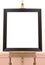 Blank empty frame on painting easel, background