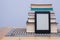 Blank eReader in front of a tower of books with bookmarks