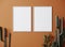 Blank frame on orange wall mock up with cactus, two vertical white poster frame on wall, mock up for picture or photo frame, empty