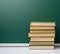 Blank green chalk school board and stack of books, back to school