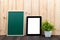 Blank green chalkborad or chalk board and tablet pc on wooden table with copy space for add text. technology concept