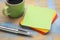 Blank green sticky note with coffee