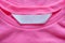 Blank laundry care clothes label on pink shirt