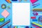 Blank lined paper with school supplies frame over a blue background