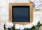A blank mock-up with a warm-coloured wooden blackboard and pink peonies