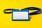 Blank nametag on a string on yellow background copy space