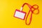 Blank nametag on a string on yellow background copy space