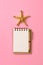 Blank note book with starfish or seashells on a pink background , summer vaction concept