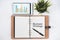 Blank notebook with BUSINESS STRATEGY word and digital tablet with business chart on white flat lay