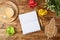 Blank notebook, coffee cup, plant and paper rocket on wooden office desk. Home workplace, freelancer and blogger concept