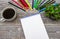 Blank notebook and colored pencil and coffee Cup on office wooden table background.