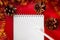 Blank notebook and pen on the background of Christmas decorations. Layout for new plans for the new year