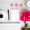 a blank notebook, pink peony flower, coffee cup, pen, sweet macarons and keyboard,