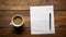 Blank notepad flat lay design with coffee cup on wooden table