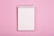 Blank notepad or notebook on a pink background. Space for inscriptions and notes