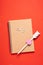 Blank notepad, pensil and wooden hearts on red background for Valentine's Day