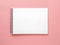 Blank notepad white page on pink desk, color background. Top vie