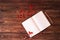 Blank open white notebook, wooden pencil and red ashberry on wooden background