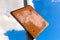 A blank orange peeling sign against a blue sky