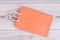 Blank orange shopping bag on wooden background.