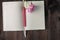 blank page of notebook and pencil ,pink flower on wood background