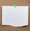 Blank paper ad with torn edges attached with a green velcro on a brown cardboard surface