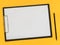 A blank paper on the balck tablet on yellow background. Flat lay