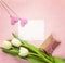 Blank paper card with white tulips, hearts and gift box on rosy